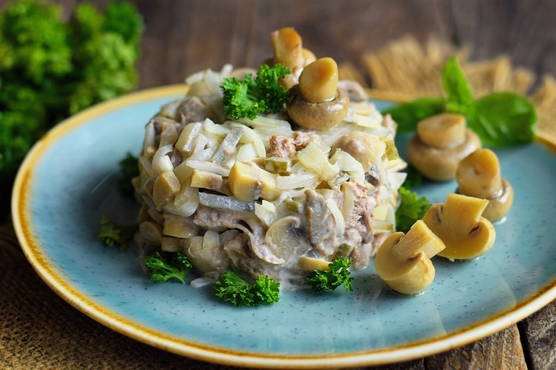 Tongue salad with pickled cucumbers and mushrooms