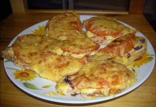 Côtelettes de poulet dans une poêle avec tomates et fromage