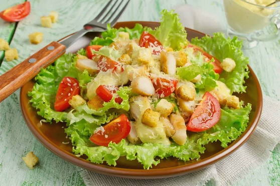 Caesar salad with chicken, croutons and tomatoes