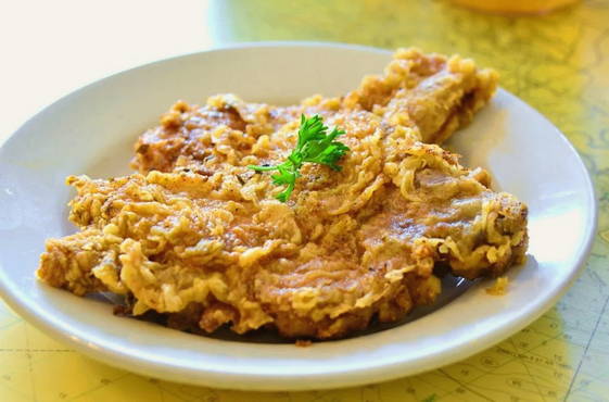 Pork chops in a frying pan in batter