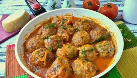 Minced hedgehogs with rice in tomato paste and sour cream in a pan