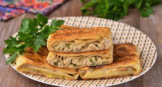 Lavash envelopes with minced meat and cheese in a pan