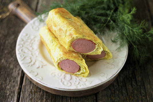 Sausages in pita bread with cheese in a pan