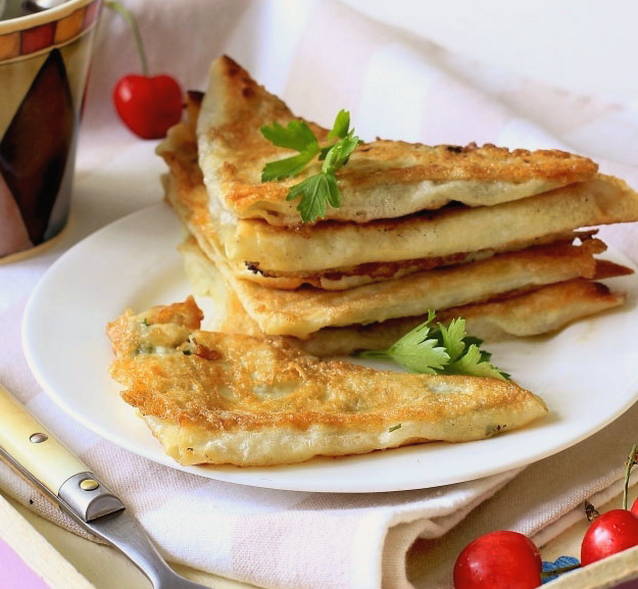 Lavash triangles with cottage cheese and herbs in a pan