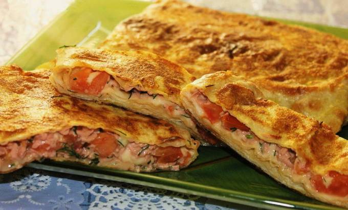 Lavash avec saucisse, tomate, fromage et oeuf dans une casserole