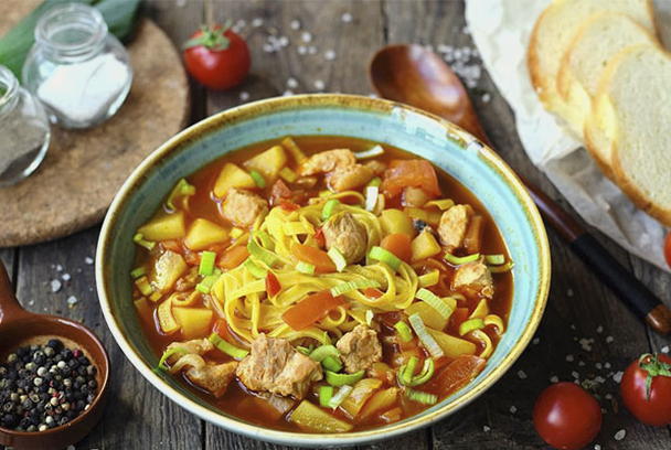 Pork lagman in a saucepan