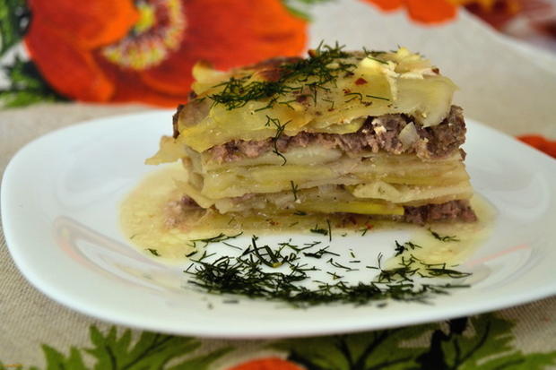 Potato casserole with minced meat, tomatoes and mushrooms in the oven