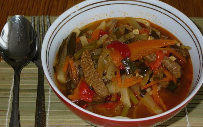 Beef lagman with noodles in a cauldron