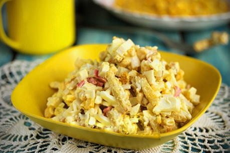 Salade avec bâtonnets de crabe, maïs, fromage et croûtons