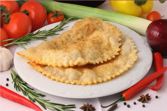 Chebureks with meat, cheese and tomatoes