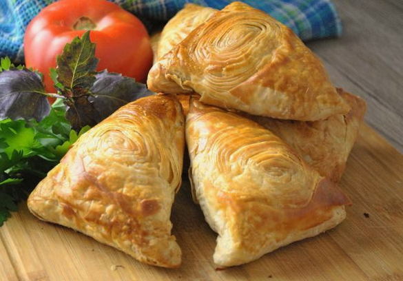 Samsa with minced meat and onions from puff pastry in Uzbek in the oven