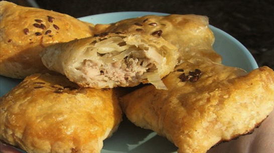 Puff pastry samsa with chicken and potatoes in the oven