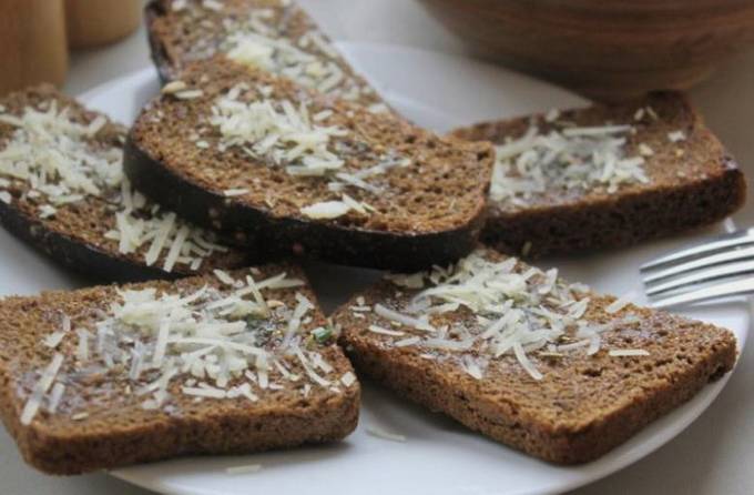 Black bread croutons with cheese and garlic in a pan