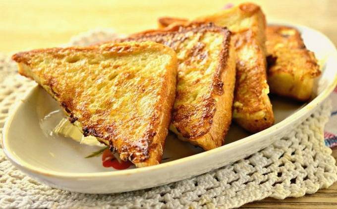 Sweet white bread croutons with egg and milk in a pan