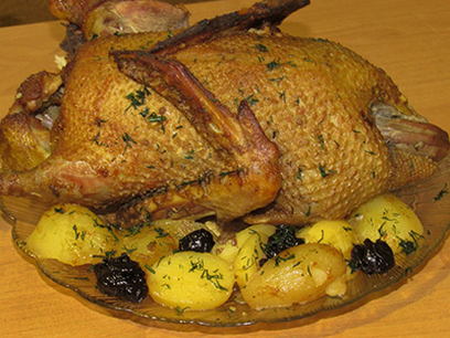 Duck with potatoes and prunes in the oven