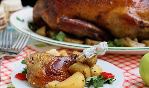 Whole duck with apples and potatoes in the oven