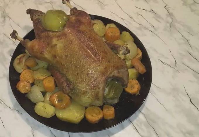 Canard aux pommes et pommes de terre dans la manche au four