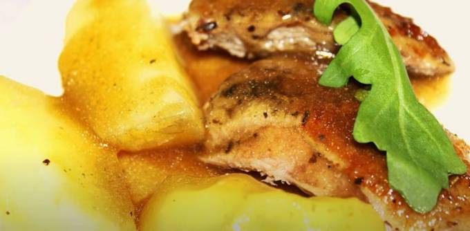 Duck with apples and potatoes in a roaster in the oven