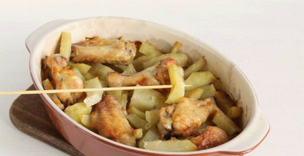 Wings with potatoes in sour cream sauce in the oven