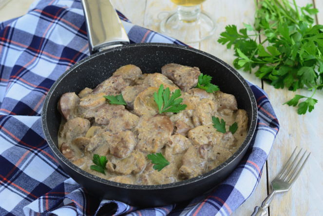 Foie de poulet à la crème sure avec oignons et champignons dans une poêle