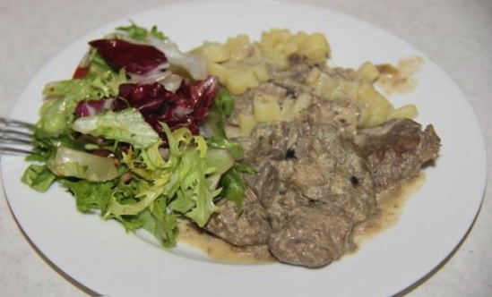 Foie de poulet aux oignons et sauce à la crème sure dans une poêle