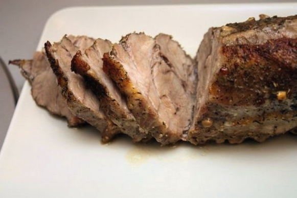 Whole piece of pork with garlic in foil in the oven