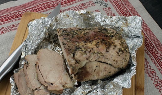 A piece of pork in foil in a slow cooker