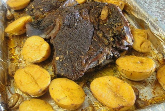 Un morceau de boeuf avec des pommes de terre cuites en papillote au four