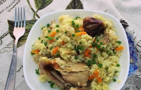 Uzbek pilaf with chicken in a saucepan on the stove