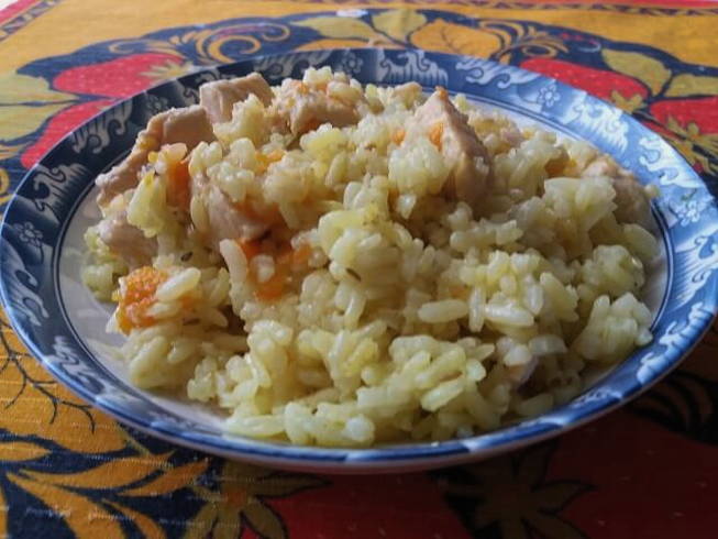 Pilaf with chicken in a cauldron on gas