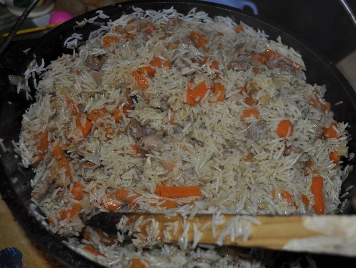 Pilaf with chicken in a cauldron on the fire