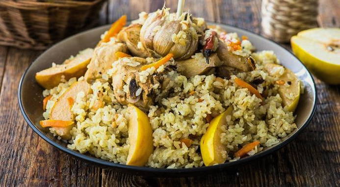 Loose pilaf with chicken in a cauldron on the stove