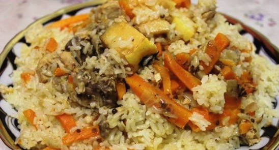 Uzbek pilaf with chicken in a cauldron on the stove