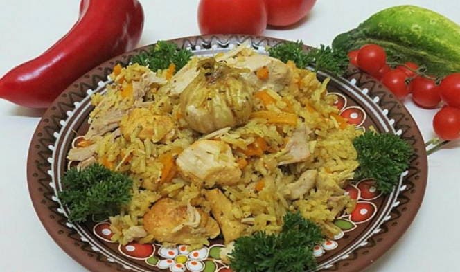 Crumbly pilaf with rice, chicken and carrots in a saucepan on the stove