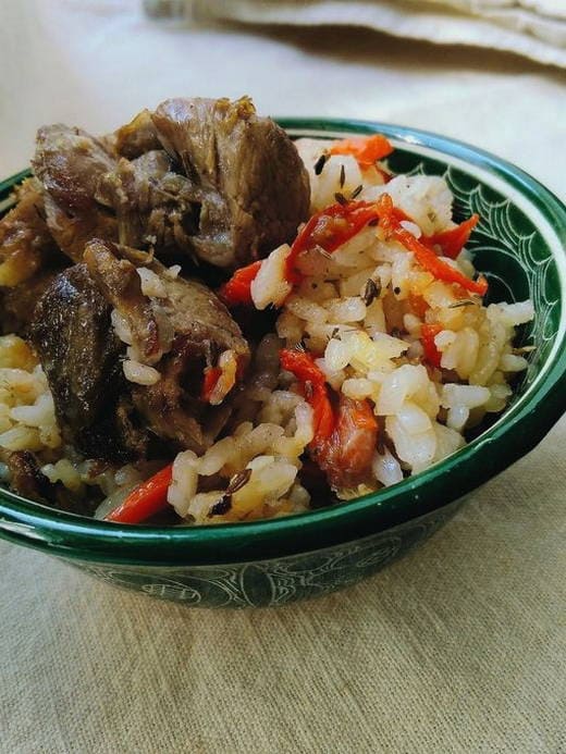 Lamb pilaf in a cauldron on gas