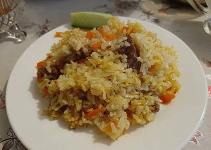 Pilaf with steamed rice and beef in a cauldron on the stove