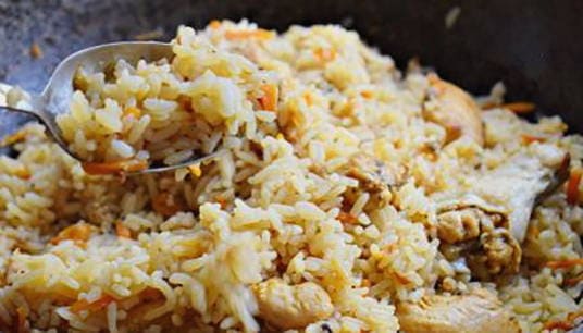 Pilaf with parboiled rice and chicken in a pan