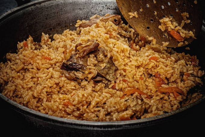 Lamb pilaf in a cauldron on the fire