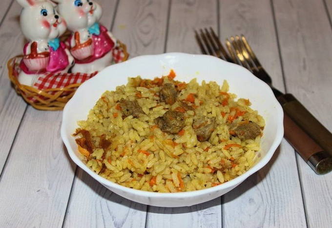 Pilaf with duck in a cauldron on the stove