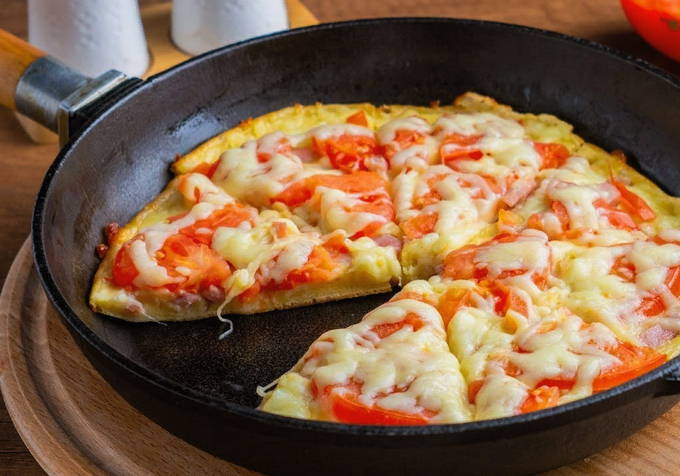 Pizza aux saucisses, tomates et fromage dans une casserole