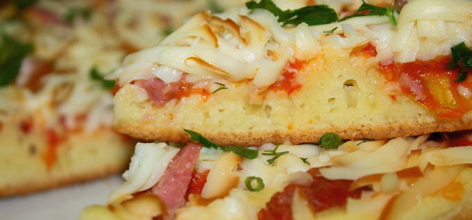 Pizza aux saucisses, fromage et tomates dans une poêle