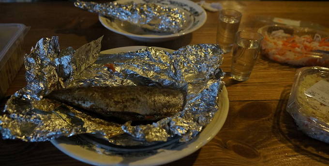 Whole mackerel in foil on a grill on the grill