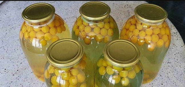 Yellow plum compote with seeds in a 3-liter jar for the winter